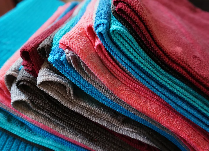 Colorful folded microfiber towels showing clean edges, loop texture and bulk color options