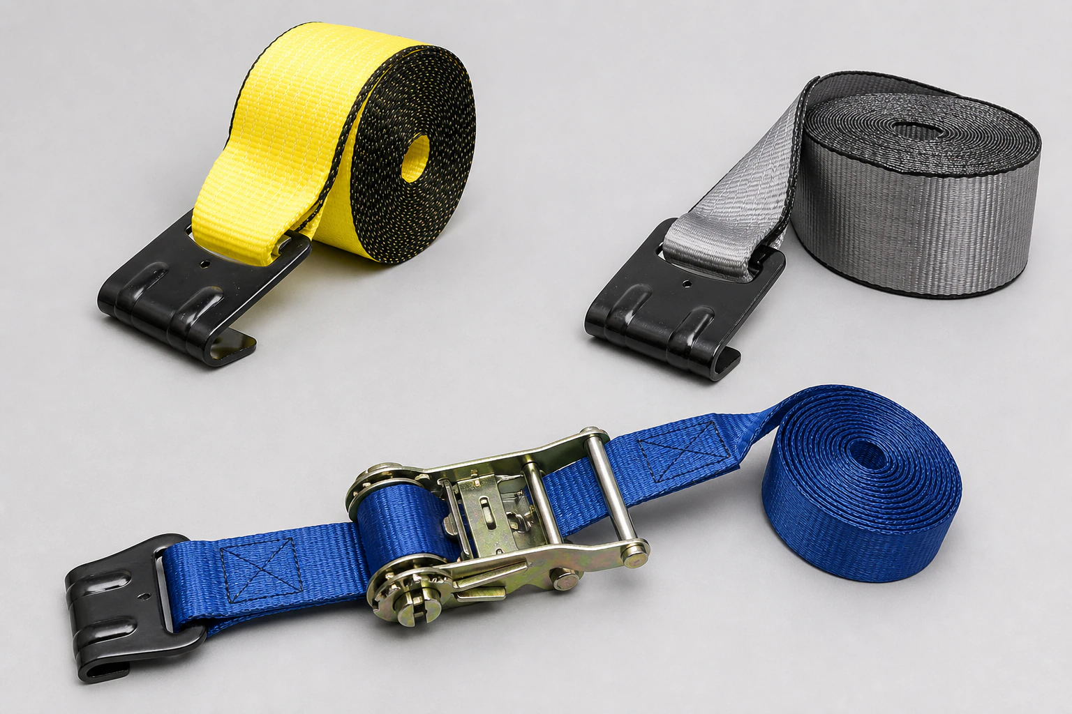 Complete yellow and gray flat-hook winch straps with one blue ratchet strap assembly fully visible on a neutral studio floor