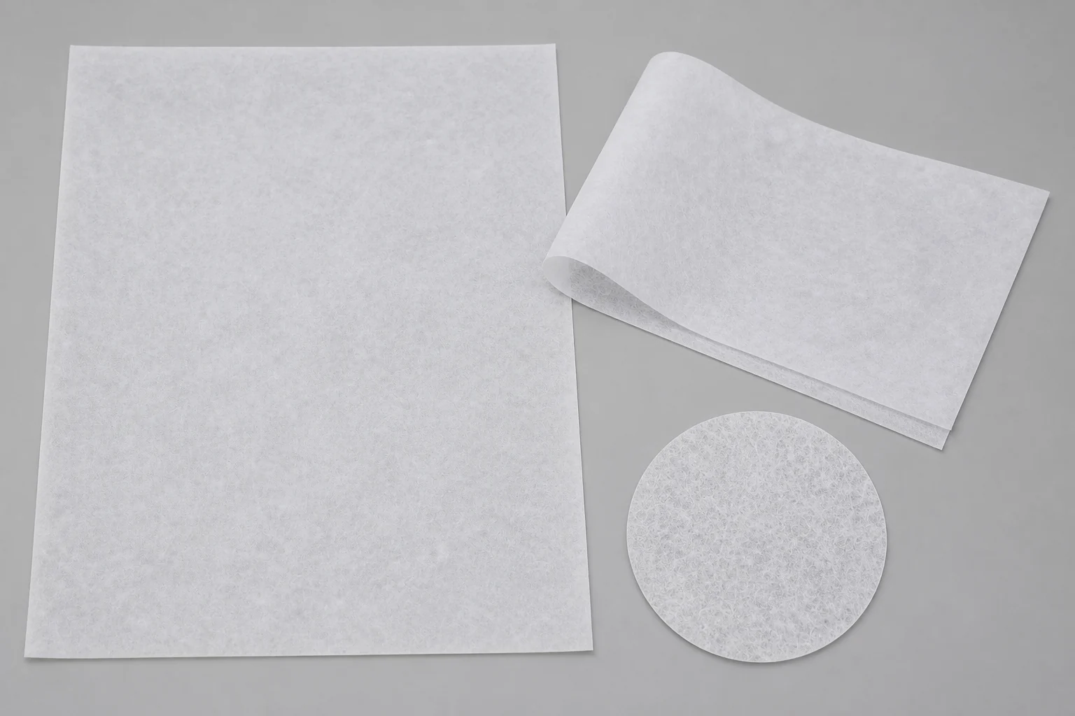 Matte fibrous nonwoven sheet, folded edge and matching web texture sample arranged for material review