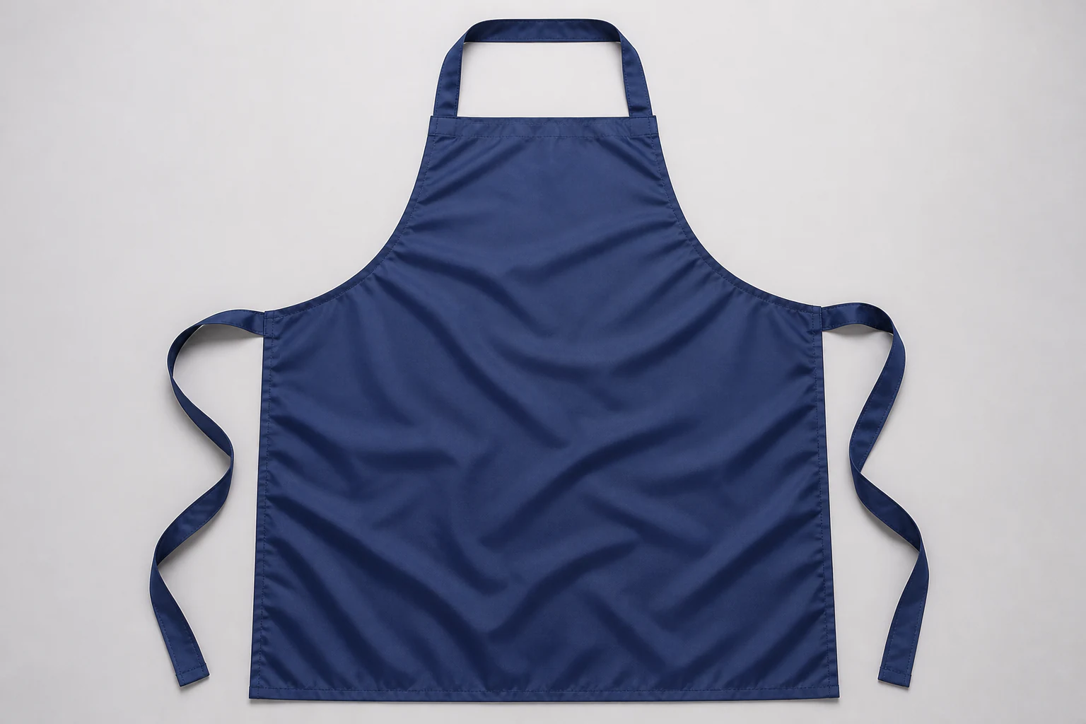 Complete navy coated bib apron laid flat with neck loop and waist ties visible