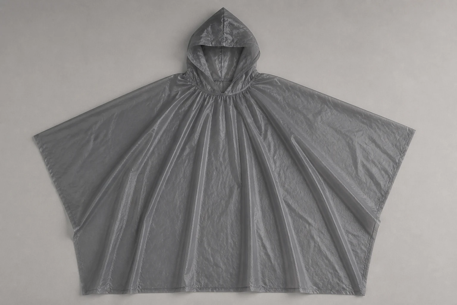 Complete charcoal nonwoven rain poncho laid fully open for geometry review