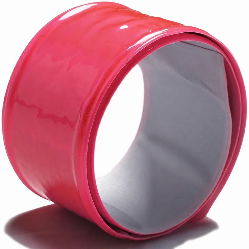 Complete pink reflective snap band showing curved outer face, rolled edge and enclosed inner structure