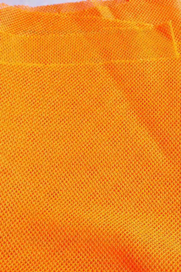 Orange high-visibility mesh showing opening pattern folds and cut edge