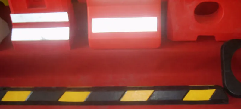 Complete orange roadway barrier modules and a black-yellow speed-bump segment shown together