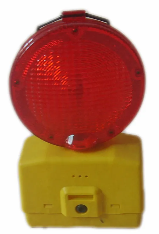 Complete red and yellow roadway warning blinker showing lens, housing and mounting base