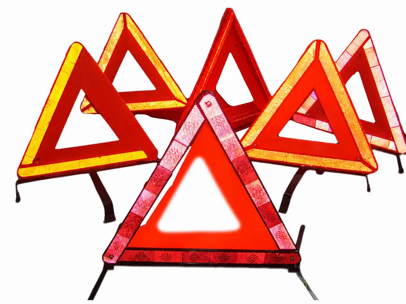 Complete folding roadway warning triangles showing reflective faces, hinge points and support legs
