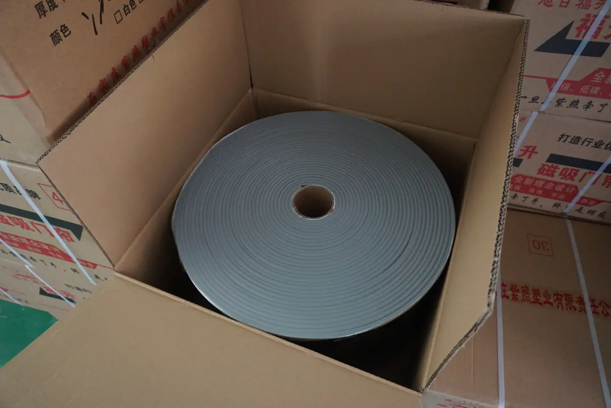 Coiled doorway material positioned inside a corrugated carton.