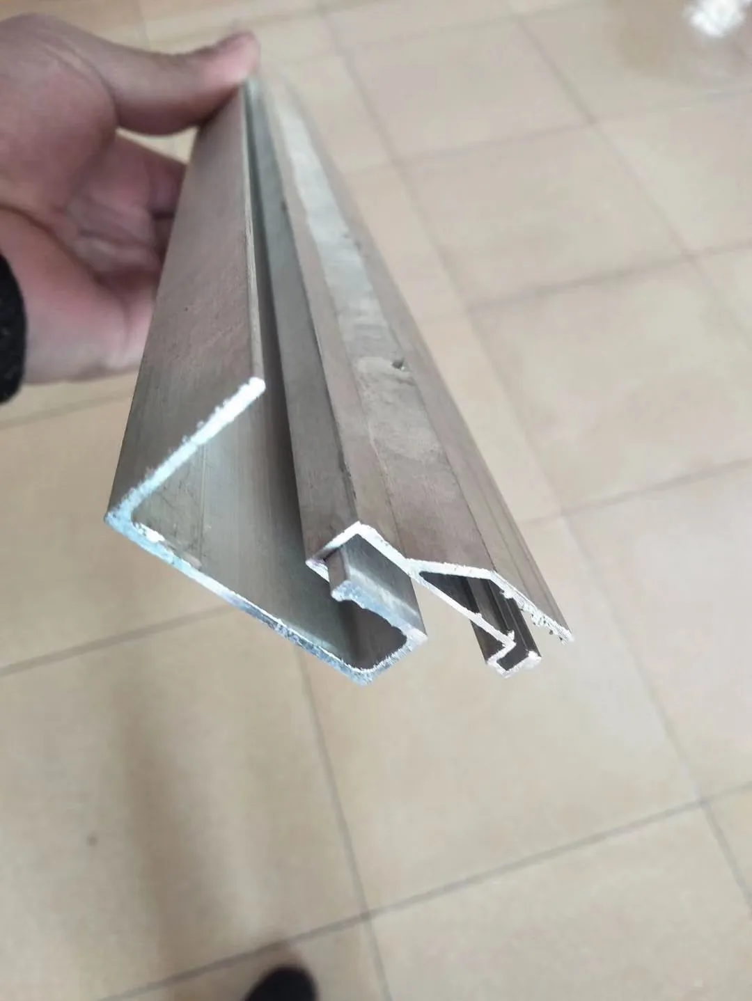 Separate metal support and hanger profiles held together for cross-section comparison.