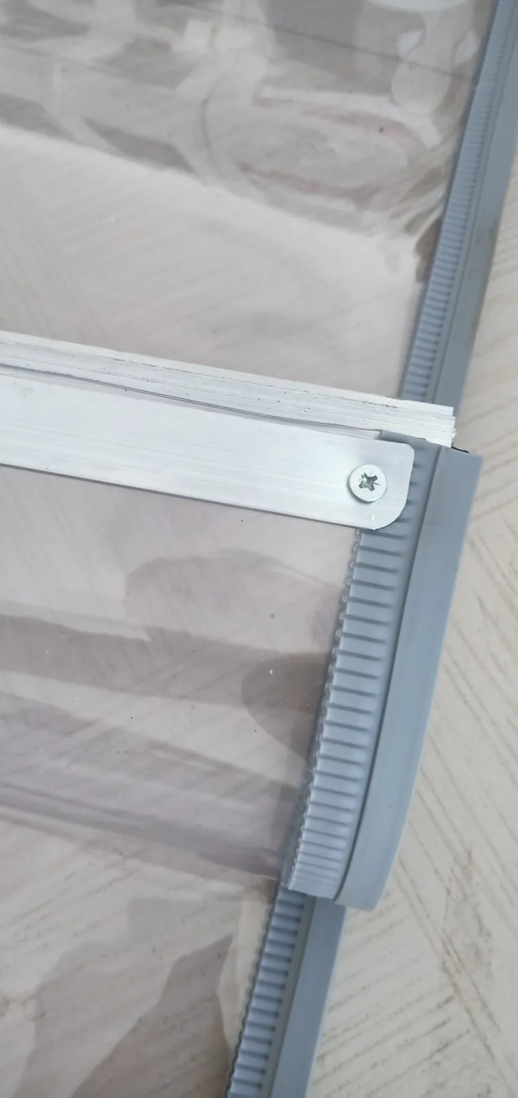 Clear PVC construction sample showing the rail and vertical edge carrier in full frame.