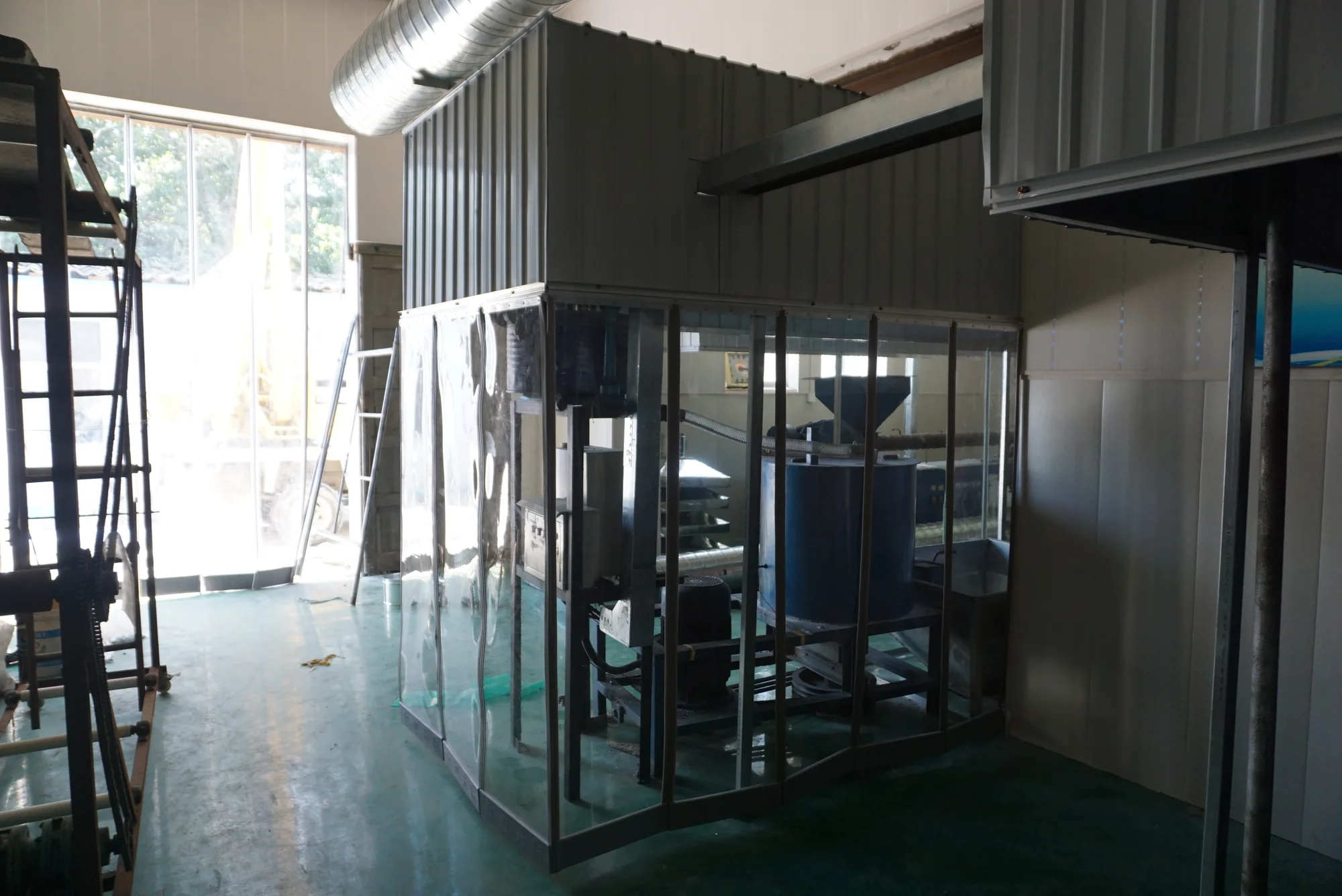 Complete clear-panel doorway enclosure installed around equipment in an industrial work area.